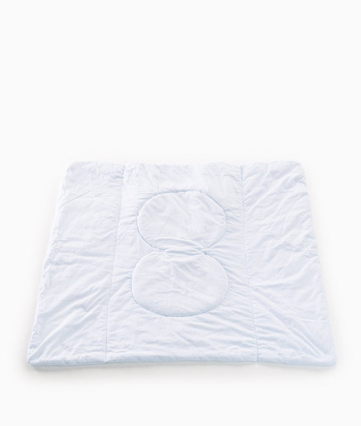 Reverse side of light blue quilted travel blanket with padded pillow zones