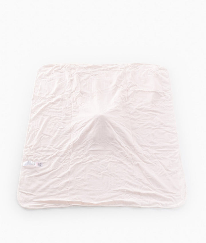 Back of pink baby blanket showing smooth cotton fabric and care label
