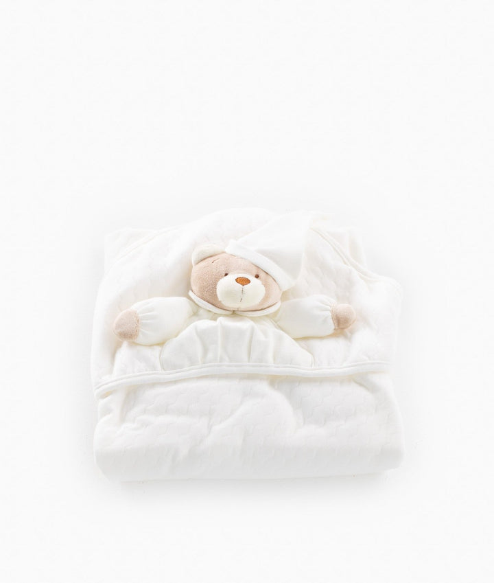 Soft plush texture of 3D beige bear head on folded white baby swaddle