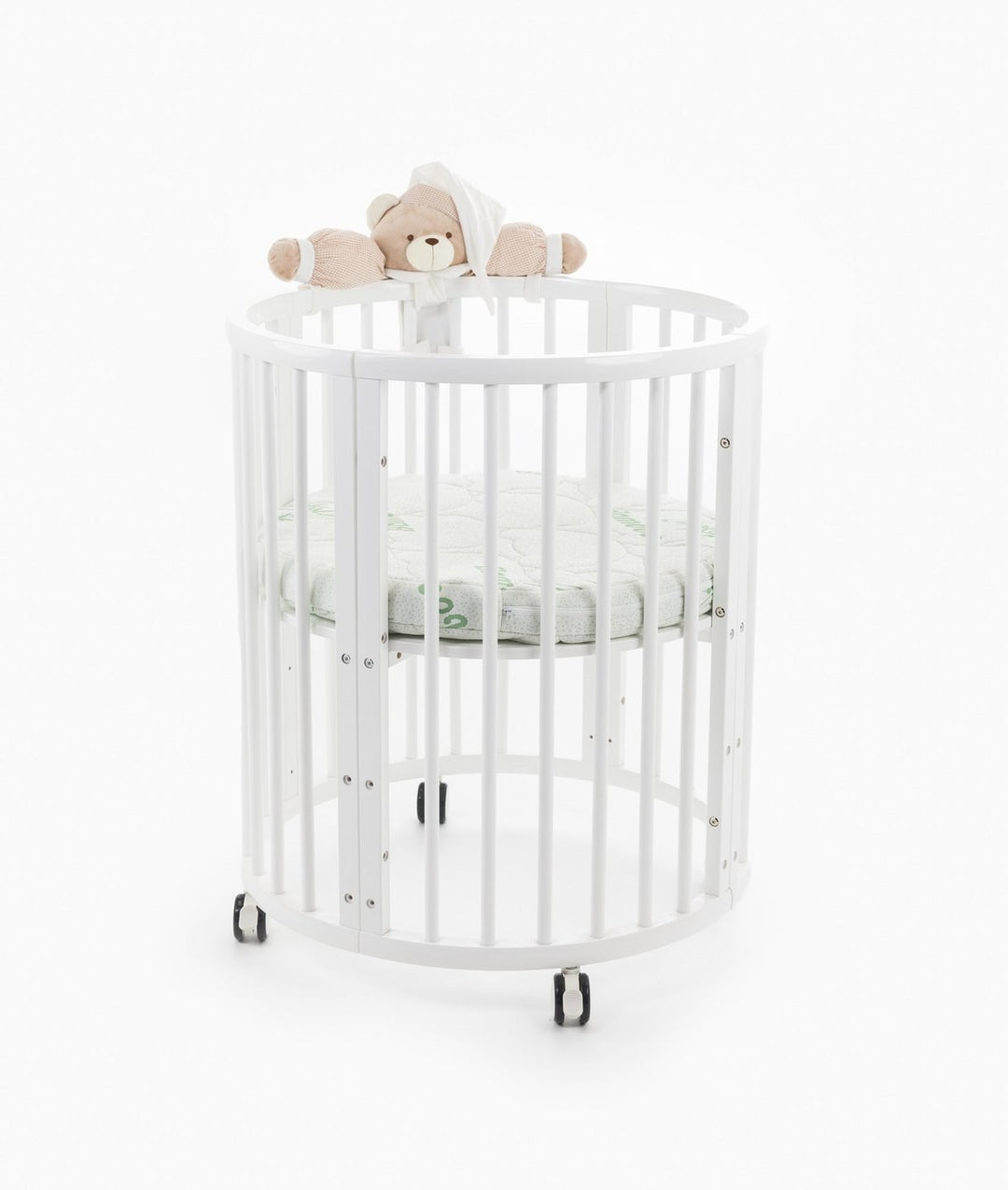 White baby cot with teddy bear design styled in a neutral nursery room