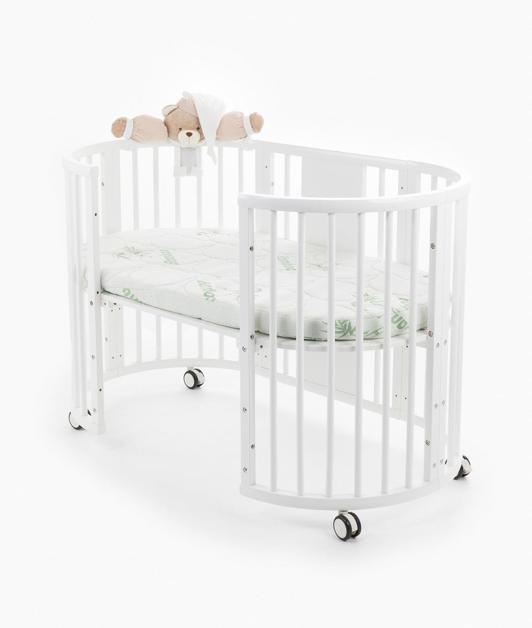White baby cot with teddy bear design styled in a neutral nursery room