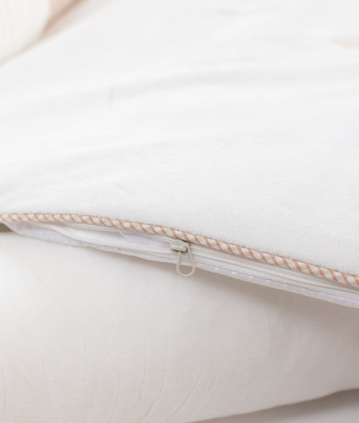Close-up of white plush outer shell zipper track with striped piping trim