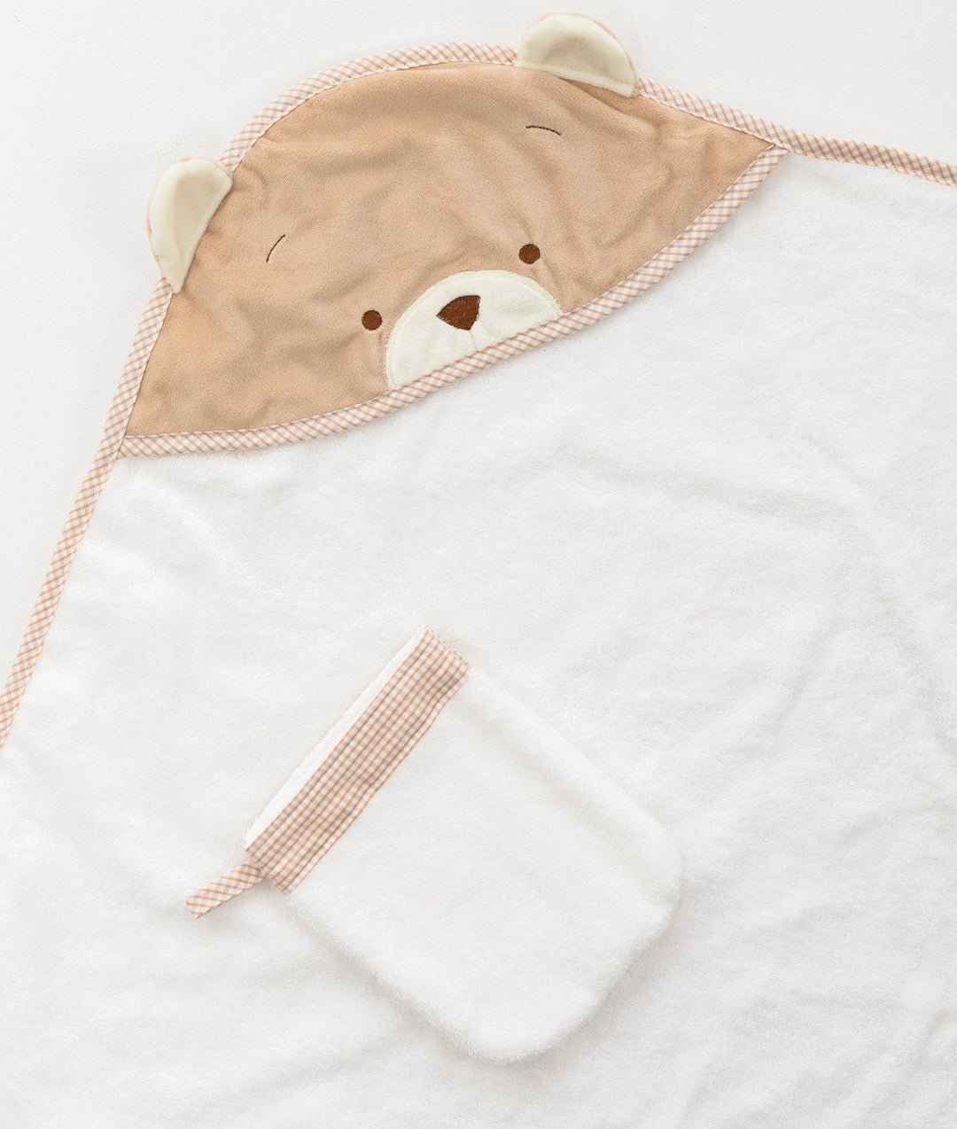 Close up of beige bear applique hood on white terry cloth baby towel