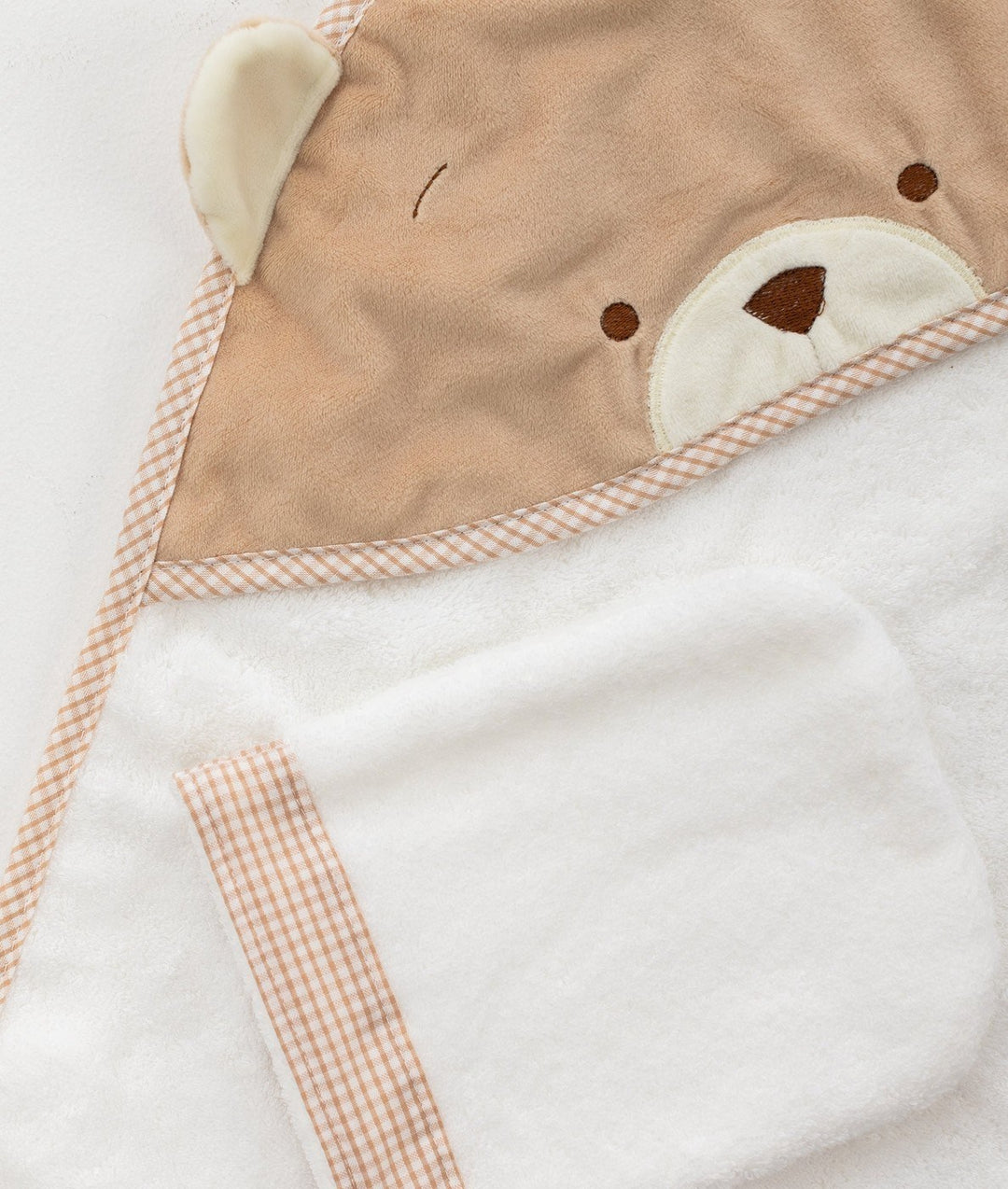 Macro shot of soft cotton texture and beige bear embroidery detail