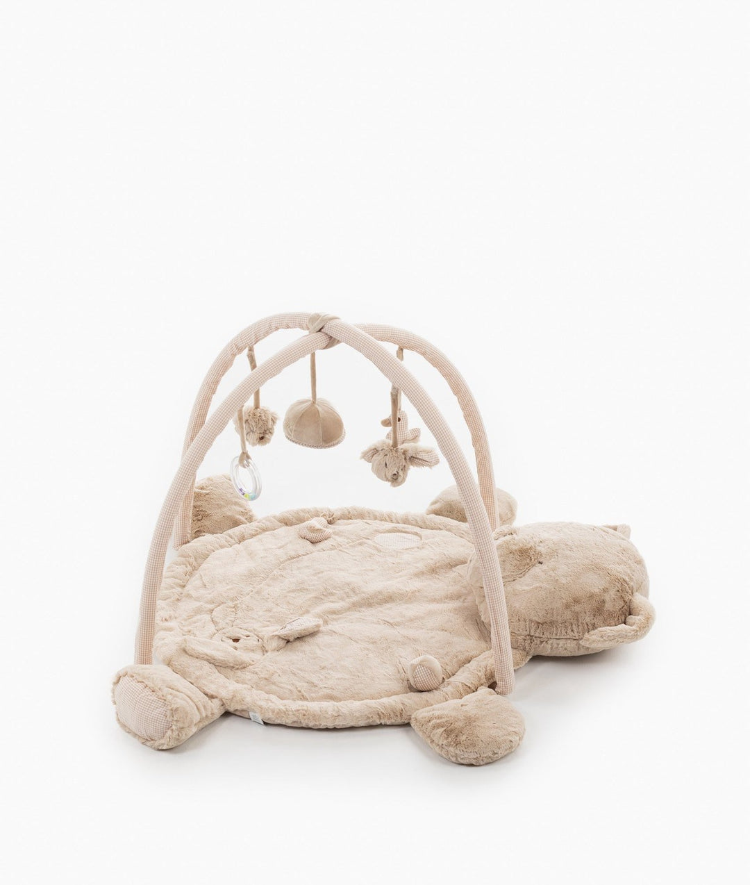 Side angle of beige bear playmat gym showing full arch structure with bell and rattle over cushion base