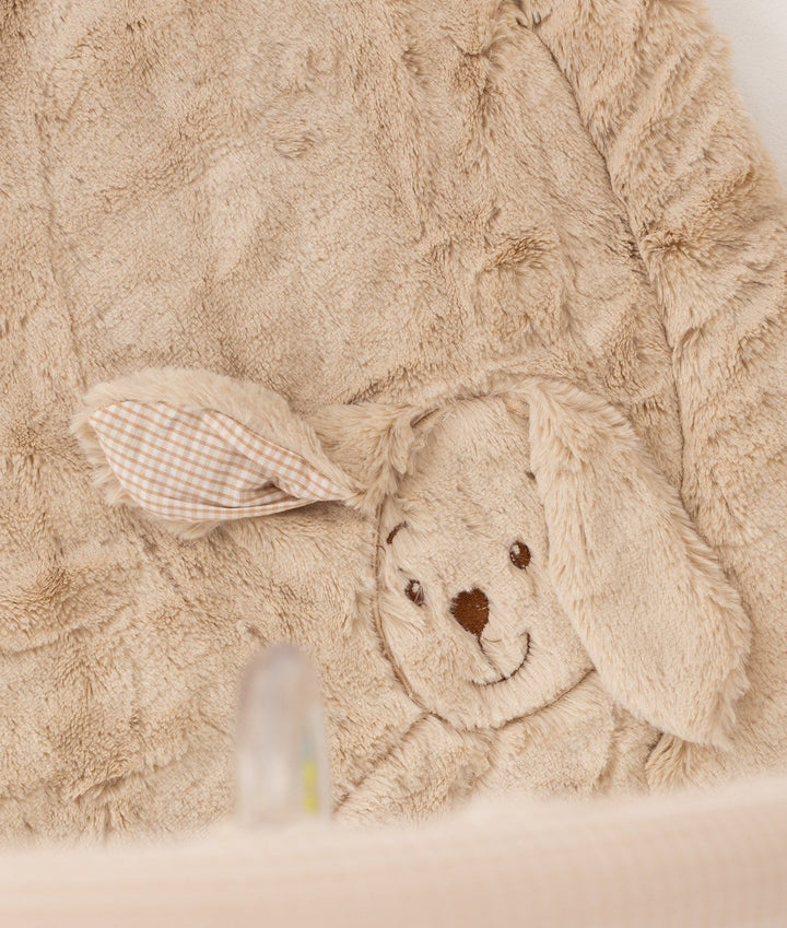 Close-up of beige bear playmat featuring embroidered smiling face and gingham check fabric ear detail