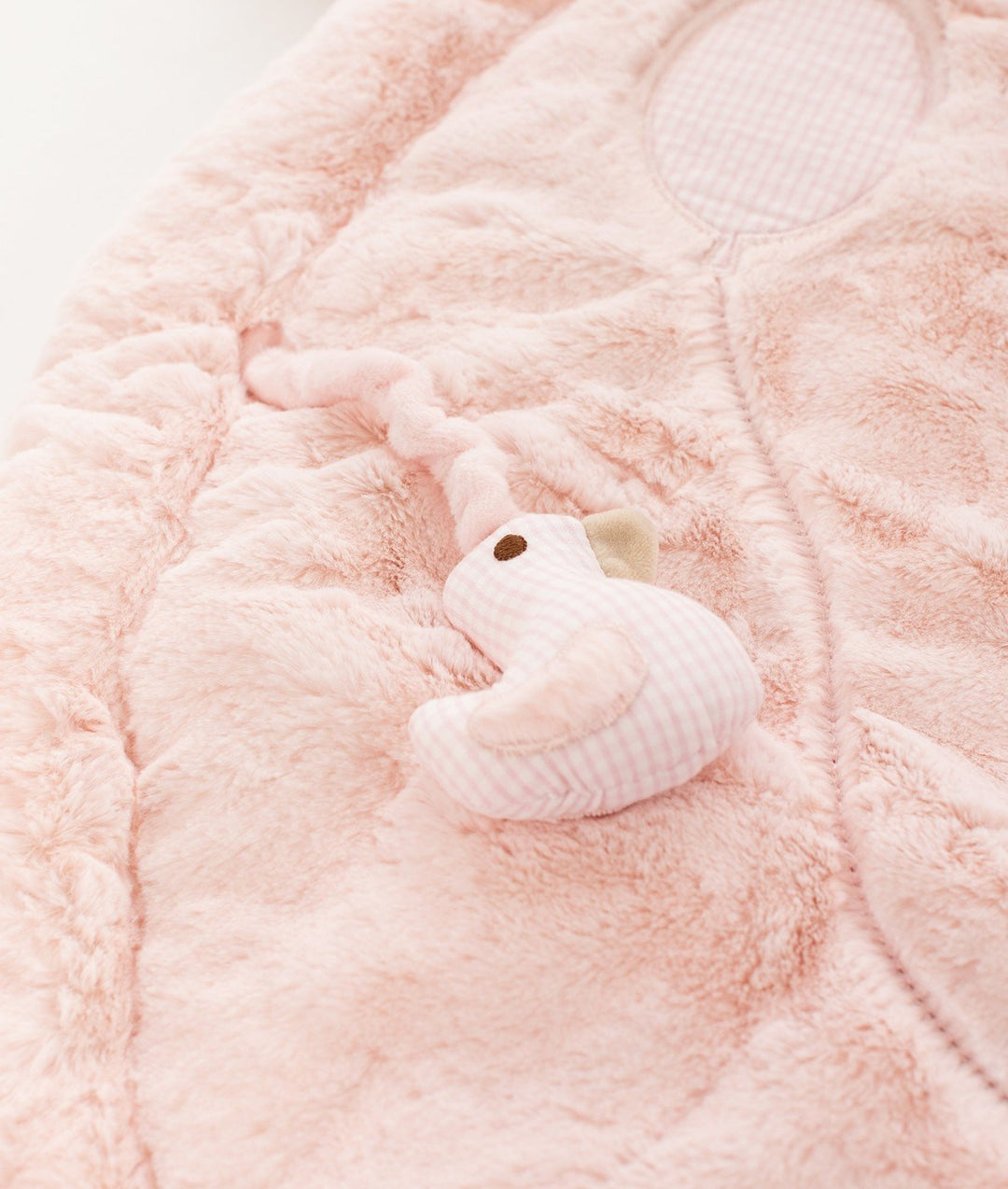 Close-up of super-soft fluffy pink playmat fabric texture and gingham bird sensory toy detail