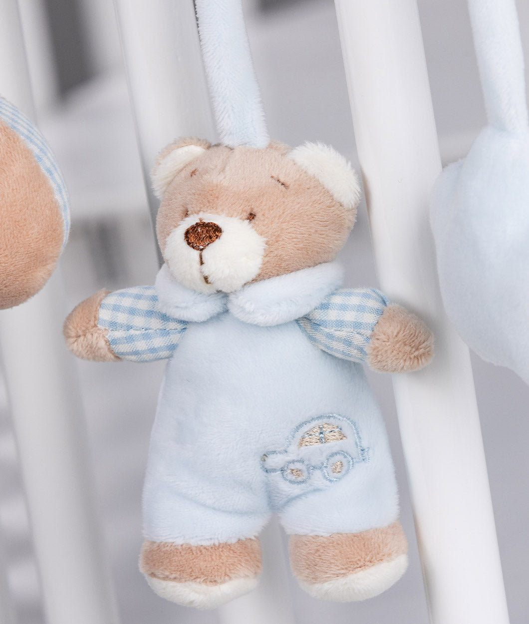 Mini teddy bear charm in light blue overalls with embroidered car design on pocket