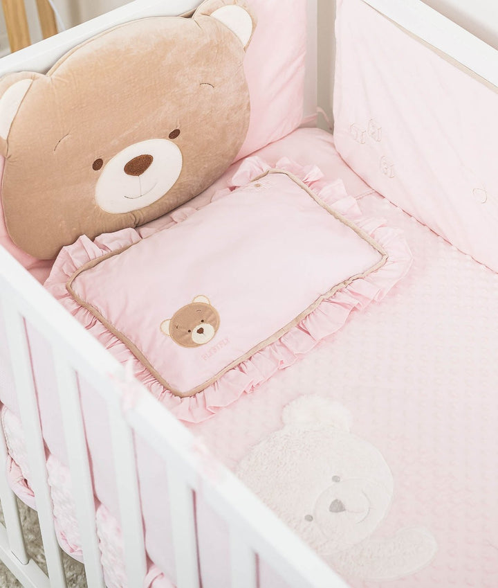 Complete pink toddler bedding set with tan bear pillow, ruffled cot pillow, and bubble dot sheet