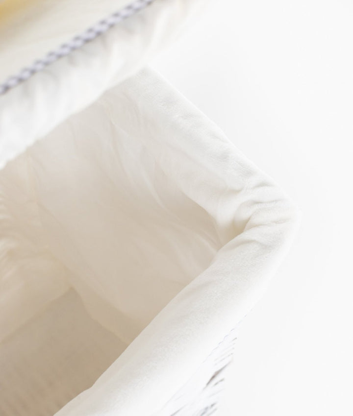 White removable fabric liner inside grey and white square wicker laundry basket with gingham trim