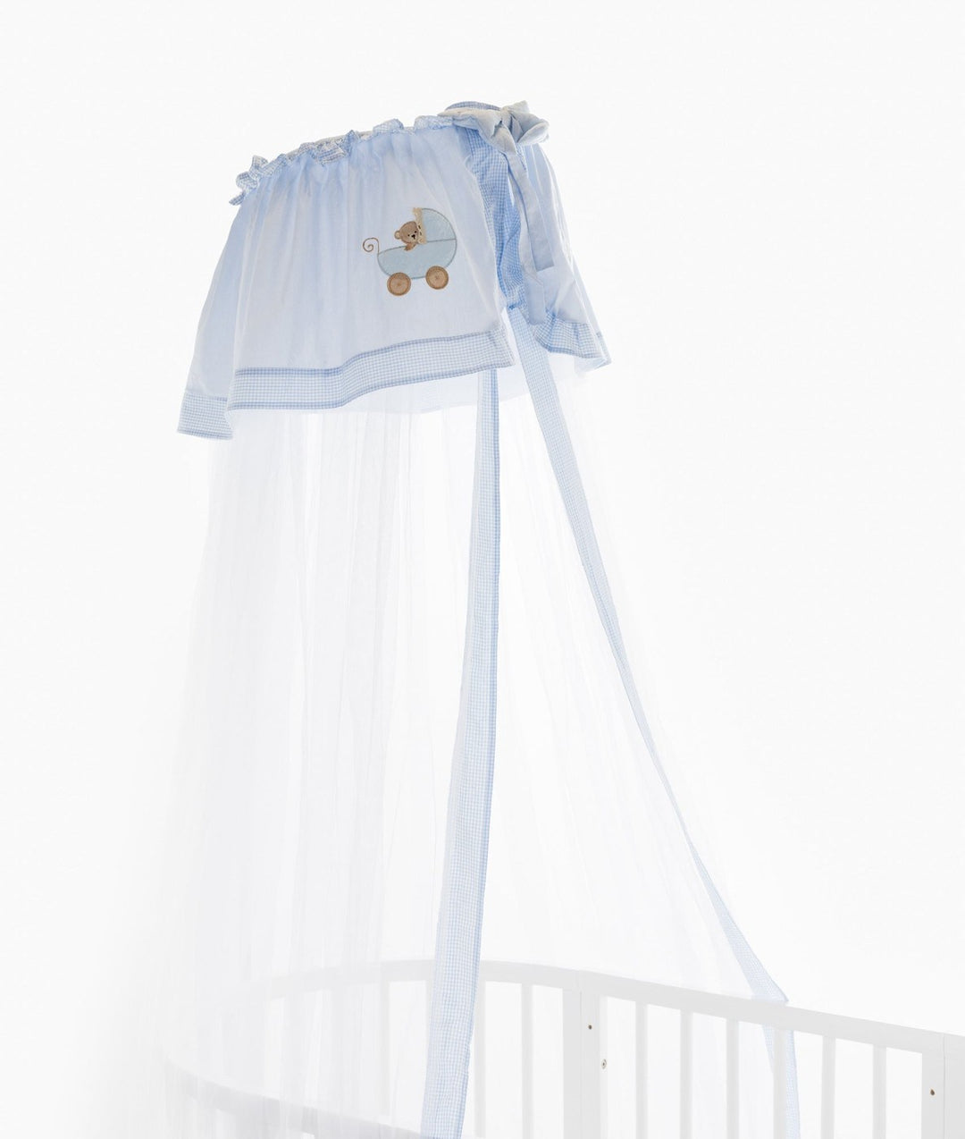 Close-up of light blue gingham trim and teddy bear pram embroidery on the gathered header of a white oval cot canopy