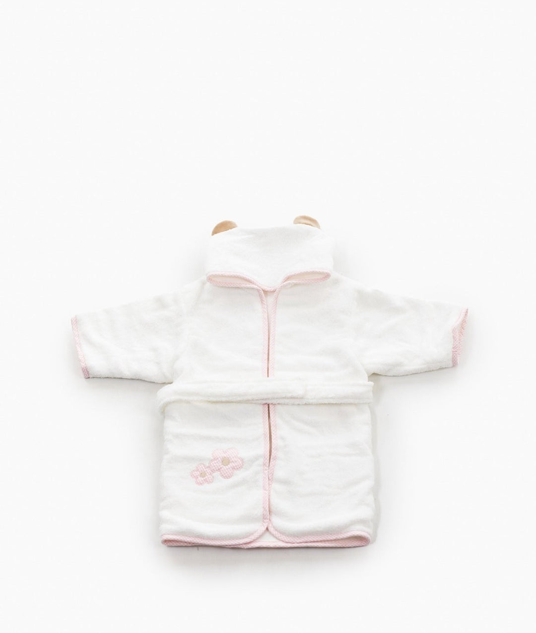 Flat lay of white hooded bathrobe with pink gingham trim and flowers