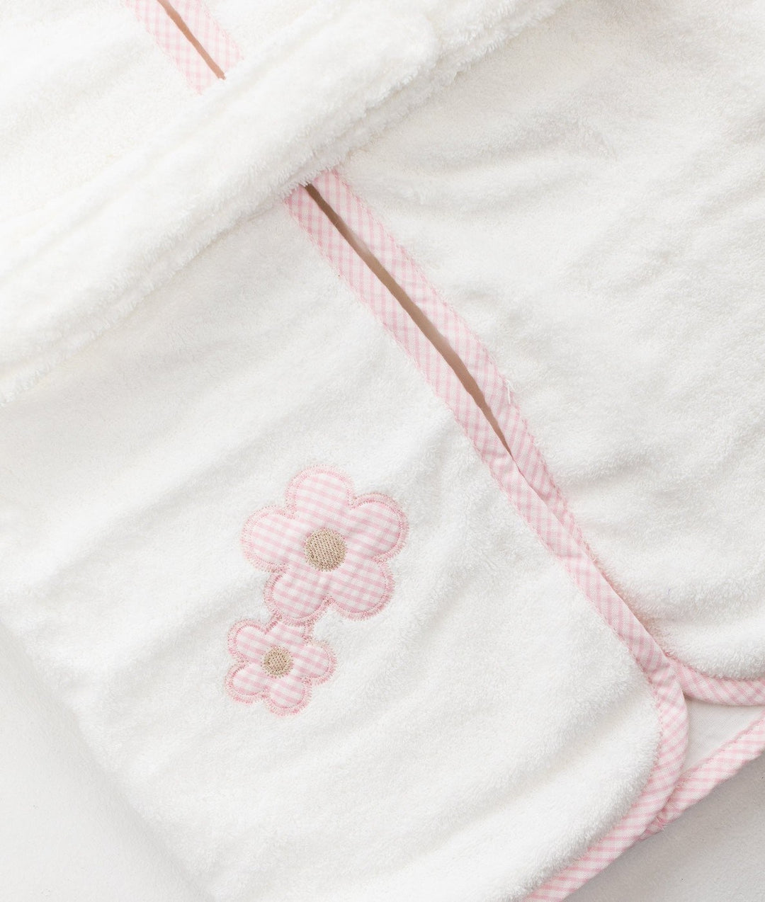Macro shot of white cotton fabric with pink checkered flower embellishments