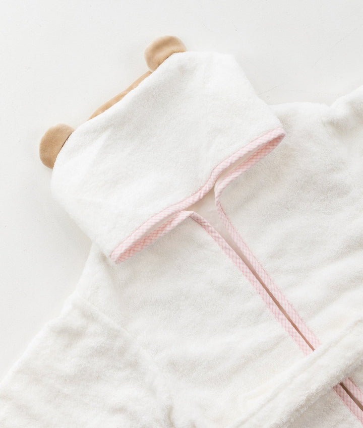 Detail of white 100% cotton hooded bathrobe with tan bear ears and pink trim