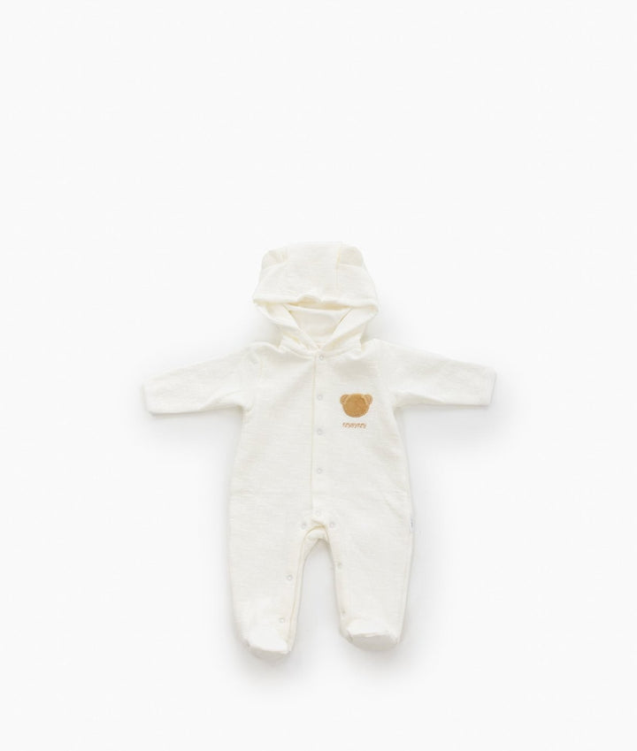 Full view of beige and white hooded bear romper with long sleeves, footed legs, front snap closure, and brown bear applique on chest