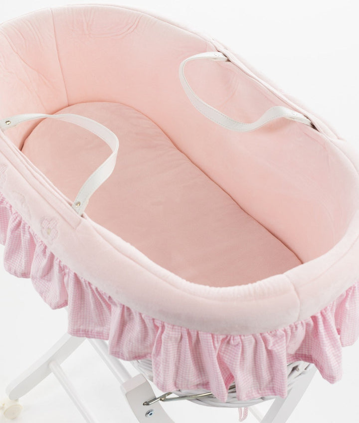 High angle view of pink cotton interior lining and white carrying straps in Moses basket