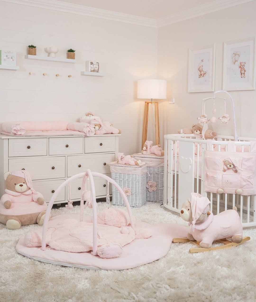 Complete pink nursery set featuring oval cot, changing table, and bear seating