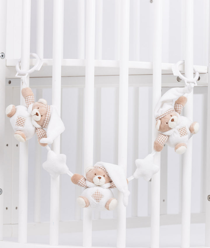 Baby activity toy draped over crib bars featuring sleeping bear dolls with star accents