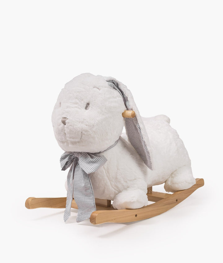 Three quarter angle of white plush rocking bunny showing curved natural wood base and checkered bow tie