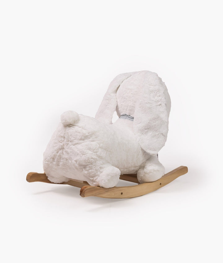 Rear view of white plush rocking bunny with floppy ears and pom-pom tail on natural wood rocker