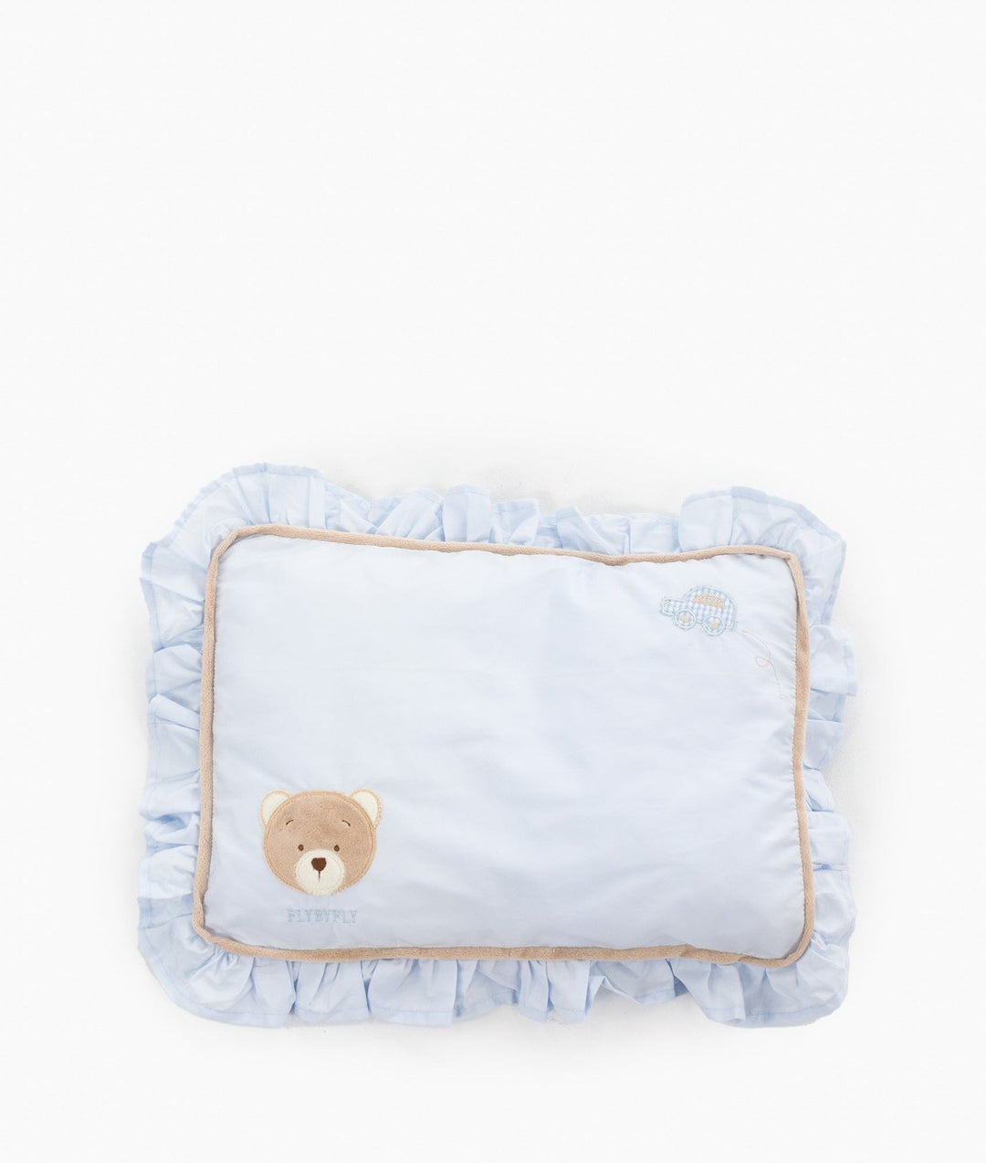 Flat lay of rectangular blue toddler ruffle pillow featuring brown teddy bear applique, brand name, checkered car embroidery, voluminous ruffles, and tan trim