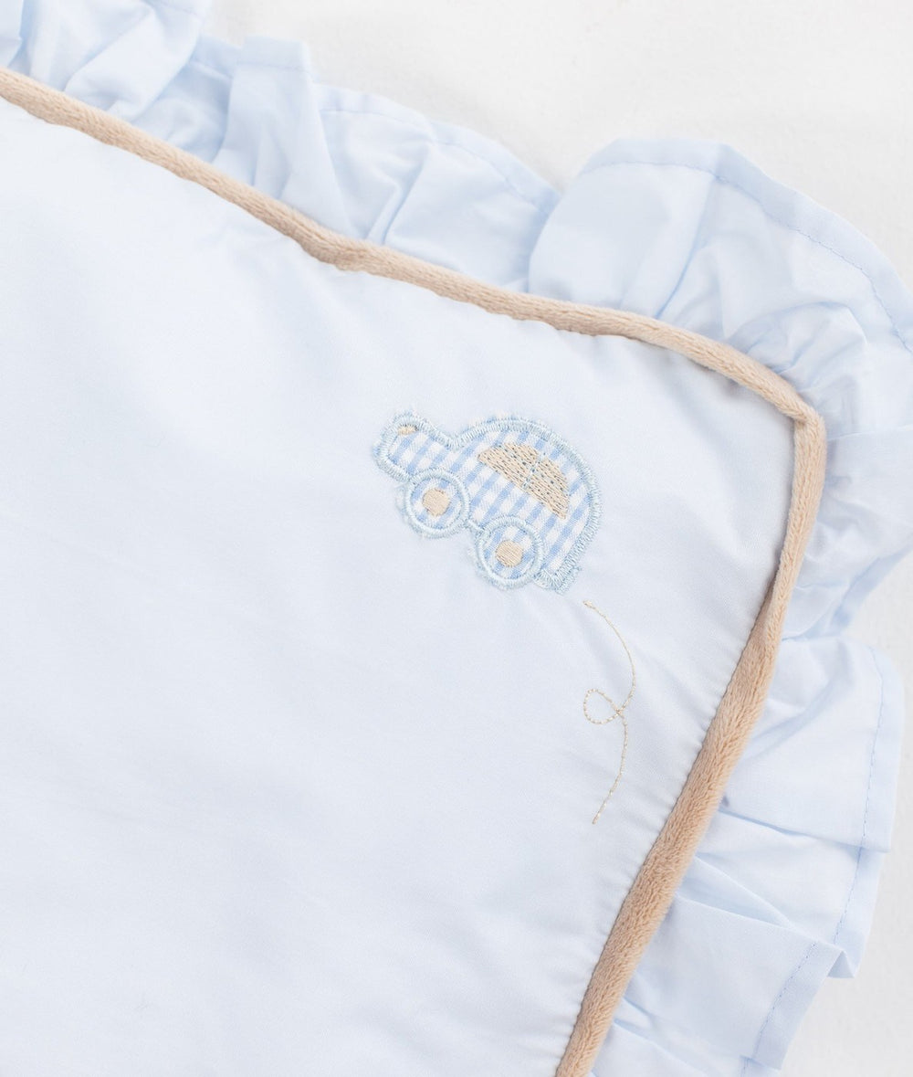 Light blue cotton toddler pillow with embroidered car motif, ruffle border, and piped edge trim